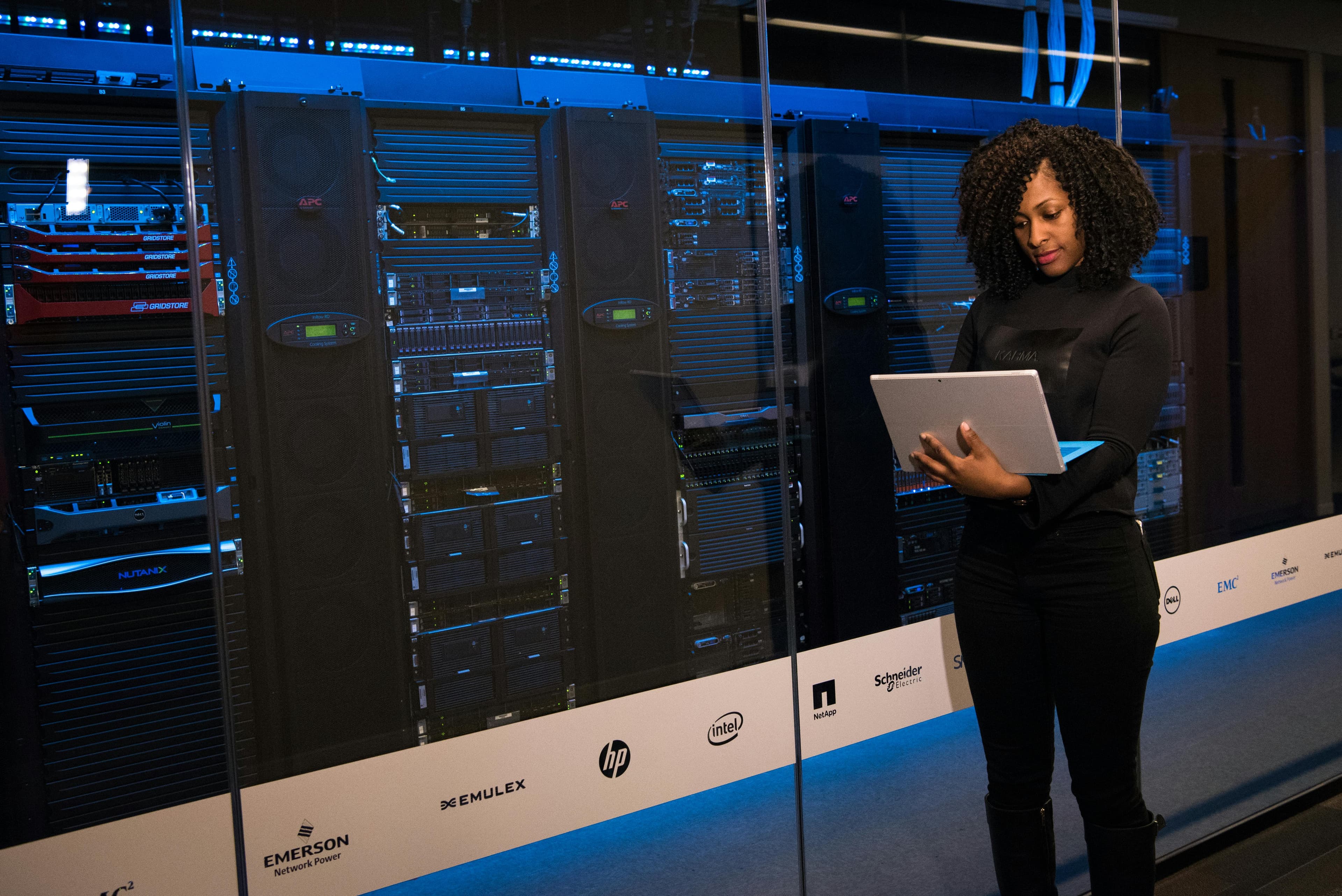 A woman in a server room, working on cloud security assessments.